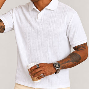 Modelo usando camisa polo branca texturizada old money, segurando café