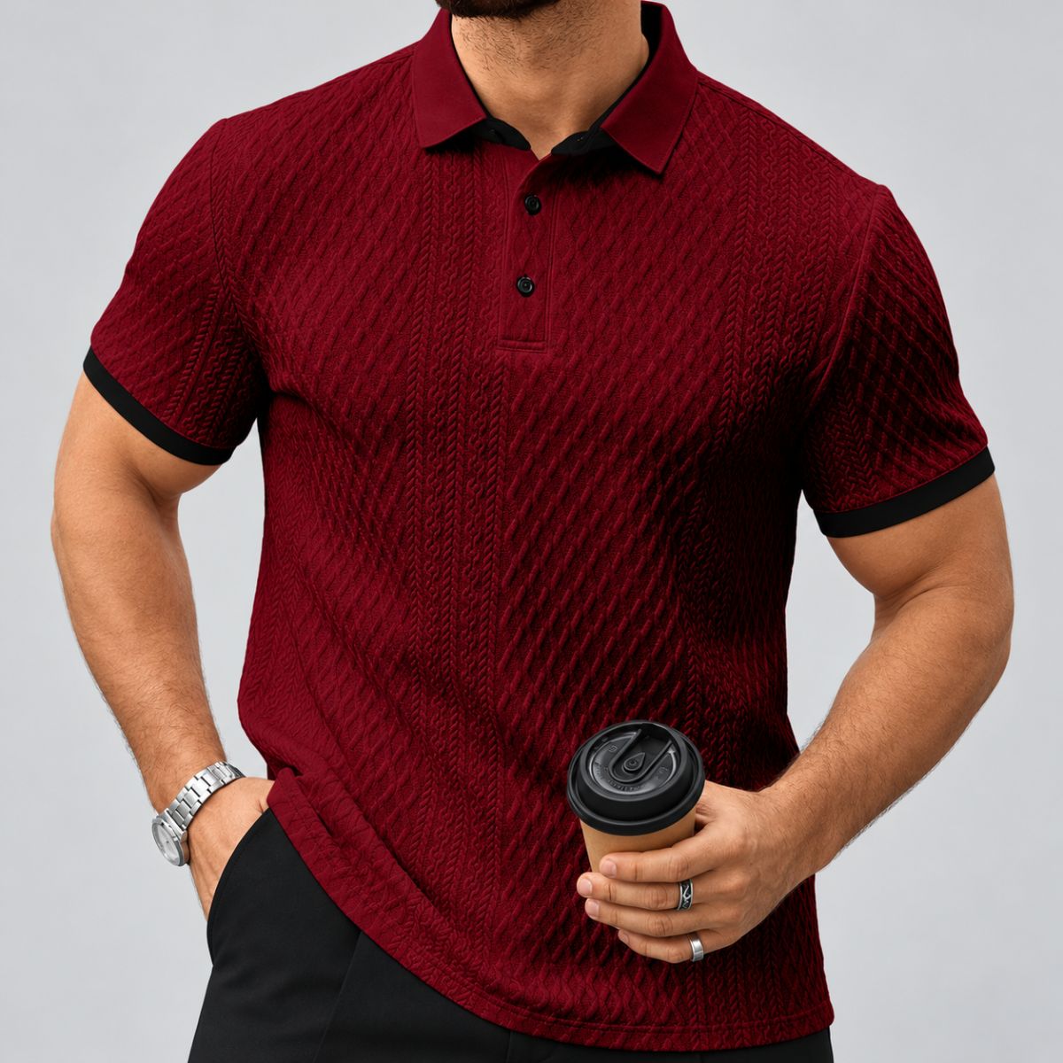 Camisa polo bordô masculina com gola de dois botões e textura em relevo, segurando café